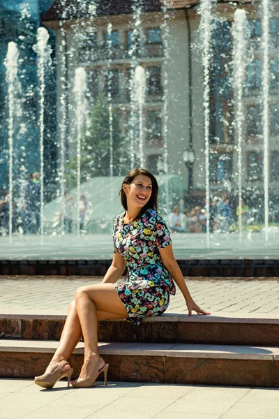 Porträt eines schönen, fröhlichen Mädchens auf dem Hintergrund des Brunnens — Stockfoto