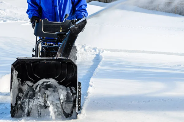 Mann Räumt Nach Schneefall Mit Schneefräse Eine Hauseinfahrt lizenzfreie Stockfotos