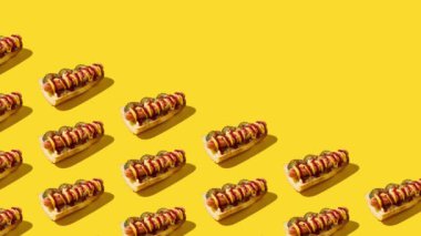 Hareket animasyonunu durdur. Sarı arka planda sandviçler çapraz olarak görünür ve kaybolur. Amerikan abur cubur konsepti.