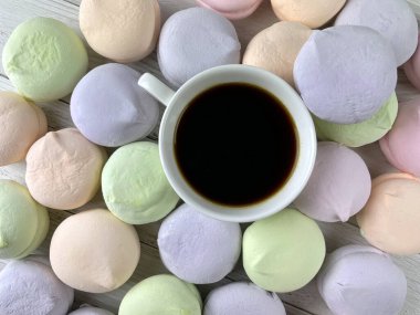 cup of coffee and multicolored natural delicious marshmallows for breakfast top view, food background with many sweets
