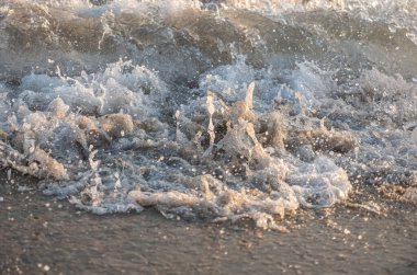 Dalgalar deniz kıyısı makrosu sıçratıyor. Yaklaş.
