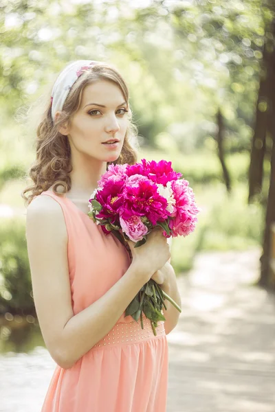 Bella ragazza con un mazzo di peonie — Foto Stock