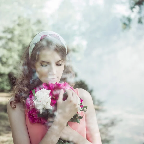 Photos through the glass beautiful girl with a bouquet of peonies — Stock Photo, Image