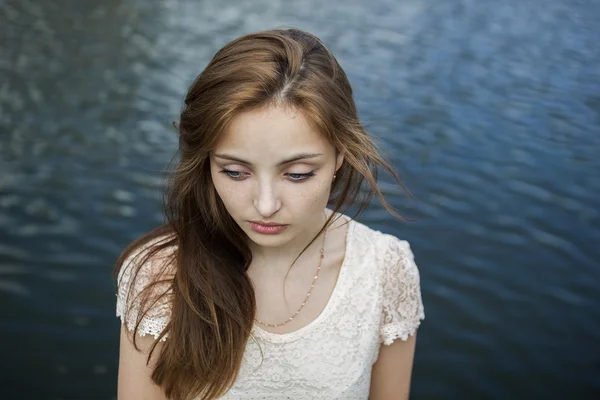 Úžasné smutná dívka s velkýma očima na pozadí vody — Stock fotografie