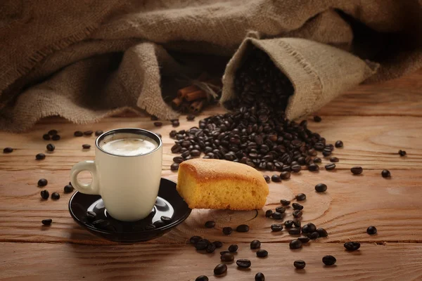A hot cup of espresso with coffee beans and Cake — Stock Photo, Image