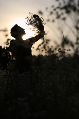 çiçek tutan güzel bir kız bir silueti 