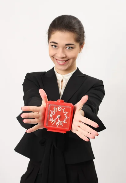 Bir gülümseme ile güzel iş kadını gösteren bir çalar saat — Stok fotoğraf