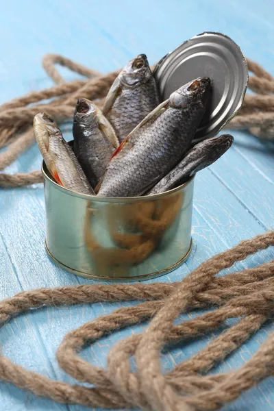 Peixe seco em uma lata em tábuas azuis — Fotografia de Stock