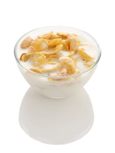 Кукурудзяні пластівці в скляній мисці з йогуртом на білому тлі — стокове фото