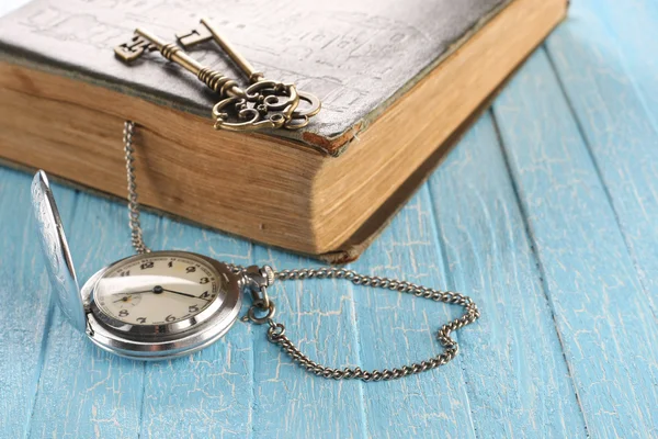 Reloj de bolsillo vintage, libro viejo y una llave de latón — Foto de Stock
