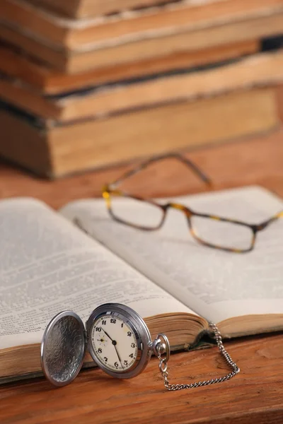 Vintage pocket watch glasses  and open old book — Stock Photo, Image