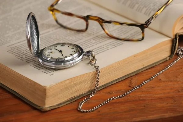 Vintage pocket watch glasses  and open old book — Stock Photo, Image