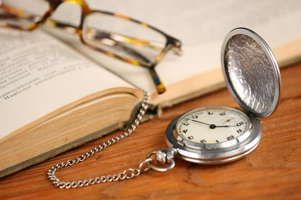 Vintage pocket watch glasögon och öppna gamla boken — Stockfoto