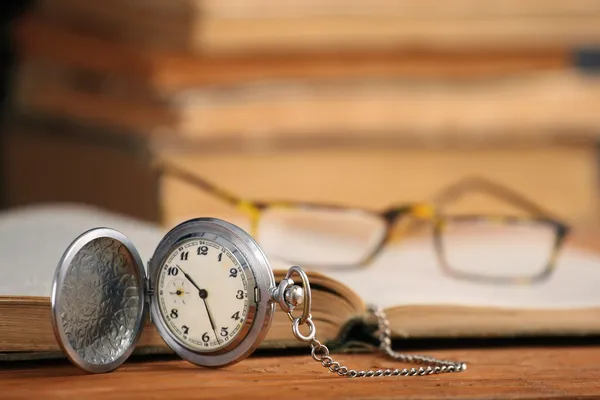 Vintage pocket watch glasses  and open old book — Stock Photo, Image