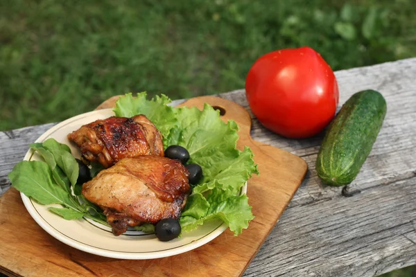 Chicken grilled on a plate with salad, olives and arugula — Stock Photo, Image