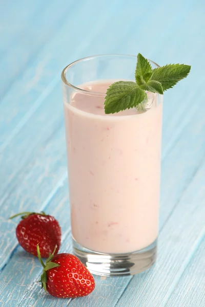 Fragola con yogurt in un bicchiere su fondo di legno — Foto Stock