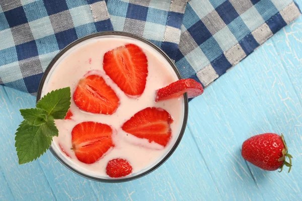 Fresa con yogur en un recipiente de vidrio sobre una tabla de madera — Foto de Stock