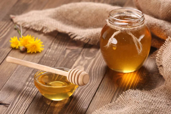 Honey in a glass bowl on a wooden boards background — Stock Photo, Image