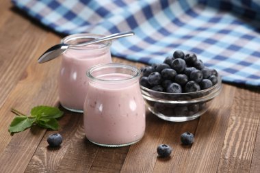 yaban mersini bir glas içinde ve yaban mersini bir cam kavanoza yoğurt