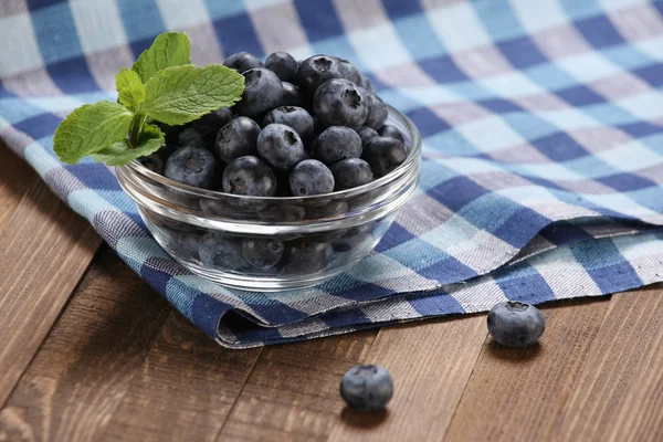 Fresh blueberries in a glass bowl on t — Stock Photo, Image