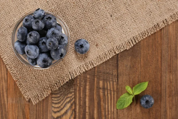 Fresh blueberries on a background of burlap  planks — Stock Photo, Image