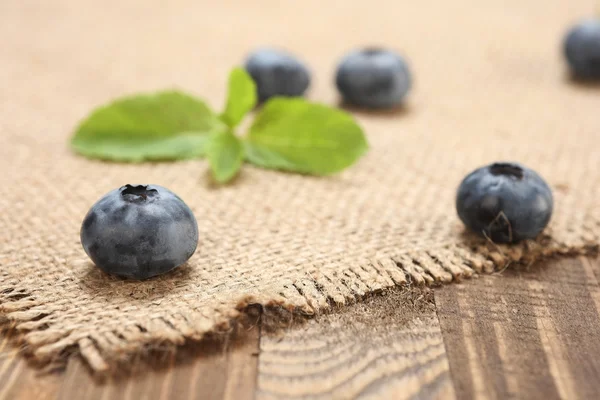 Fresh blueberries on a background of burlap and wooden — Stock Photo, Image