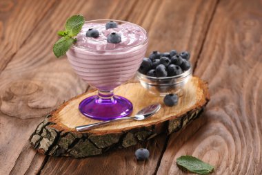 bir gla, yaban mersini ve yaban mersini bir cam kase yoğurt