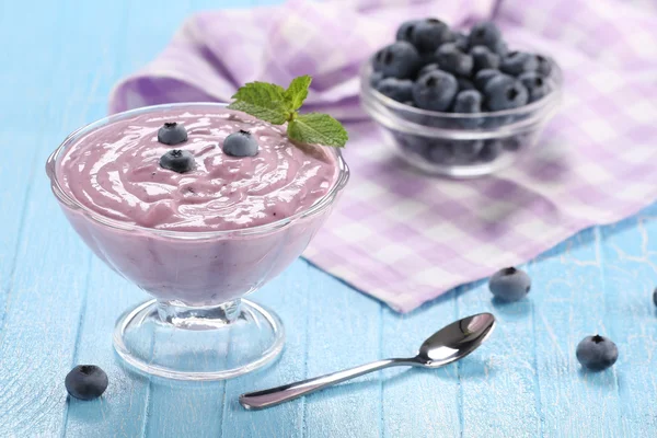 Yogurt con mirtilli in una ciotola di vetro e mirtilli in una gla — Foto Stock