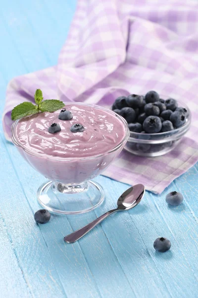 Yogurt con mirtilli in una ciotola di vetro e mirtilli in una gla — Foto Stock