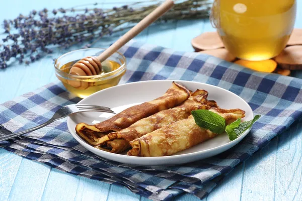 Crêpes avec du miel dans une assiette, le miel dans un bol en verre et la — Photo