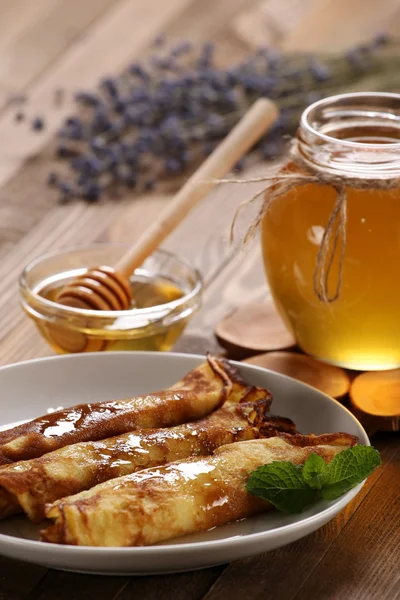 Pfannkuchen mit Honig auf einem Teller, den Honig in einer Glasschüssel auf einem l — Stockfoto