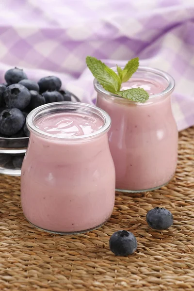 Yogurt with blueberries in a glass jar and blueberries in a glas — Stock Photo, Image