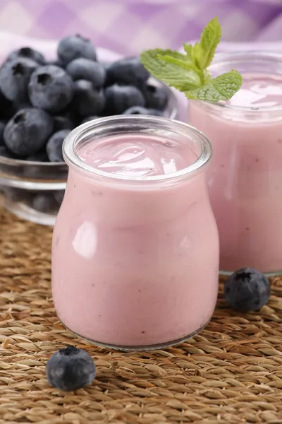 Yogurt con mirtilli in un barattolo di vetro e mirtilli in una ciambella — Foto Stock