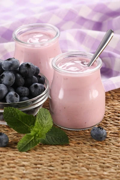 Yogurt with blueberries in a glass jar and blueberries in a glas — Stock Photo, Image