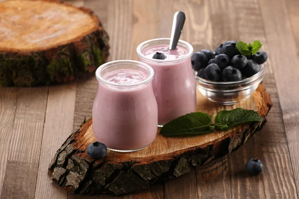 Yogurt with blueberries in a glass jar and blueberries in a glas — Stock Photo, Image