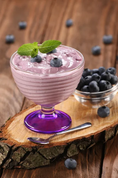 Yogurt con mirtilli in una ciotola di vetro e mirtilli in una gla — Foto Stock