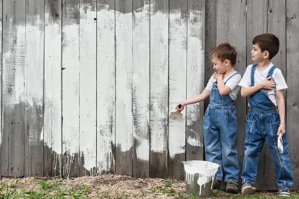 Meninos com pincéis e pintura em uma parede velha — Fotografia de Stock