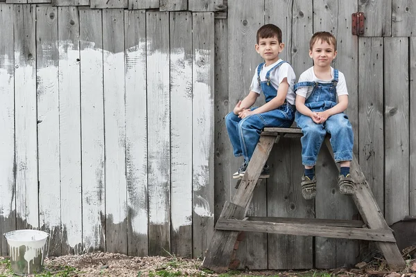 Boys with brushes and paint at an old wall — Stock Photo, Image
