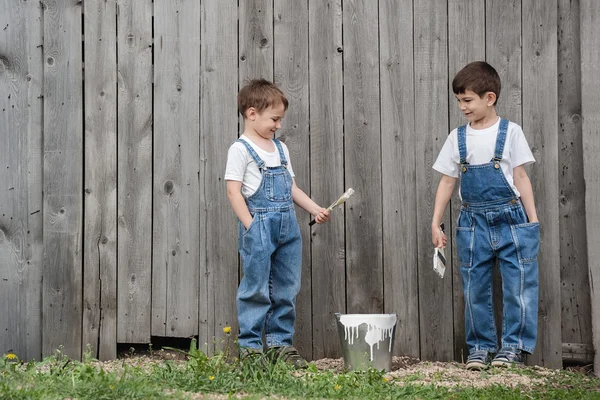Boys with brushes and paint at an old wall — Stock Photo, Image