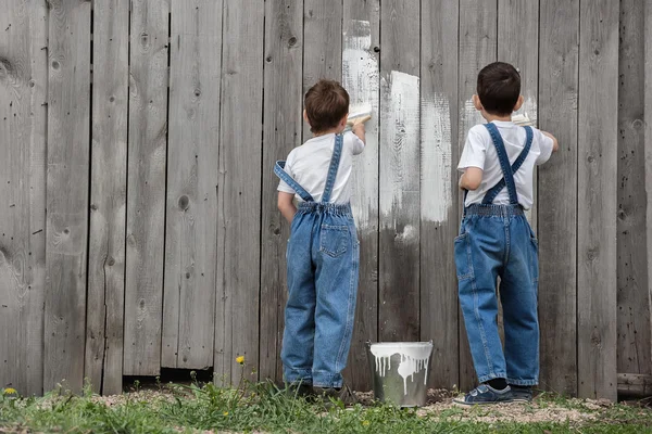 Jungen mit Pinsel und Farbe an einer alten Wand — Stockfoto