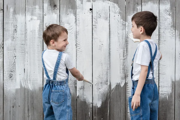 Meninos com pincéis e pintura em uma parede velha — Fotografia de Stock