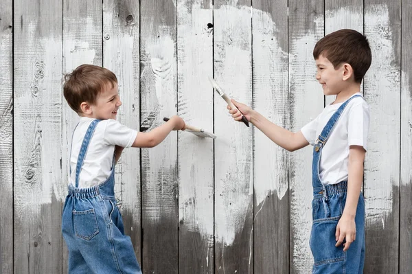 Garçons avec des pinceaux et de la peinture à un vieux mur — Photo