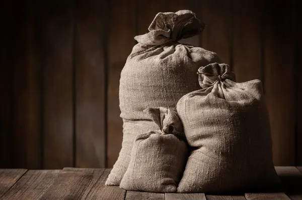 Sacks of grain on old boards — Stock Photo, Image