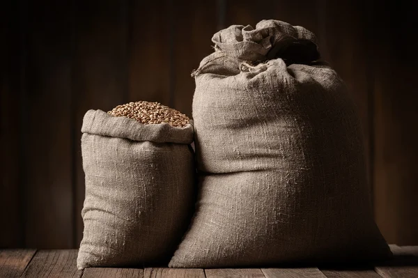 Sacks of grain on old boards — Stock Photo, Image