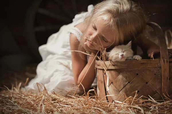 Girl with a kitten on hay — Stock Photo, Image