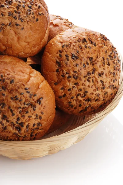 Buns with sesame in a woven basket — Stock Photo, Image