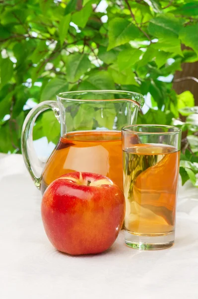 Яблочный сок в графине на столе — стоковое фото