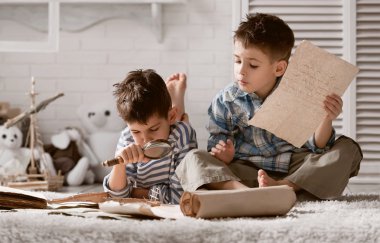 fiúk utazó tanulmányozása térképek és könyvek