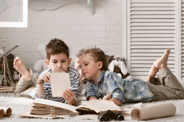 fiúk utazó tanulmányozása térképek és könyvek