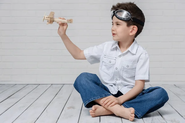 Boy plays with airplane — Stock Photo, Image